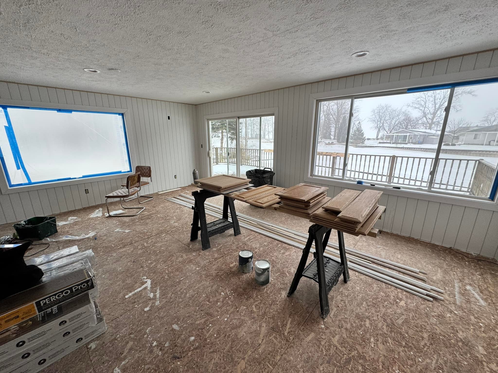 Lake house renovation in progress — drywall ceiling, wall prep, and trim materials staged for installation