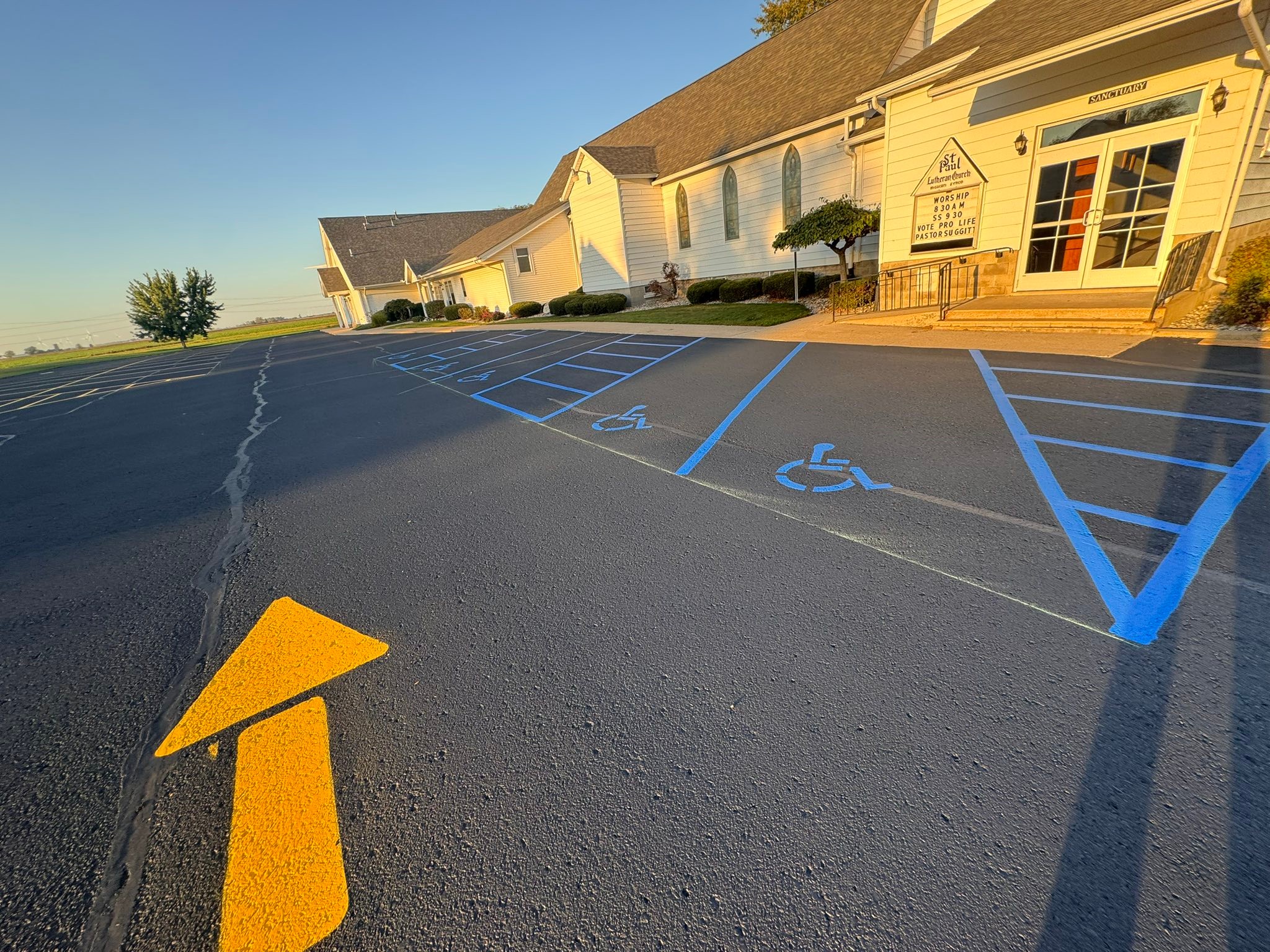 Freshly painted yellow line striping and ADA parking markings at Linkville church parking lot, Bad Axe MI